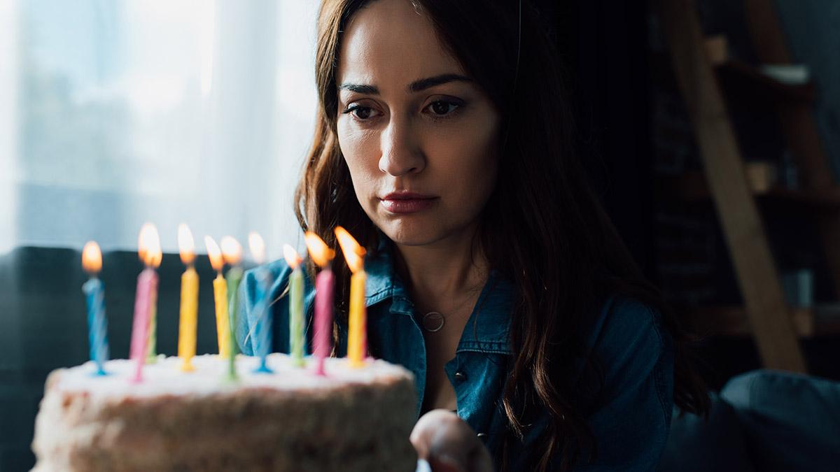 Article Cards Featured Image selective focus of sad woman looking at birthday cake with candl