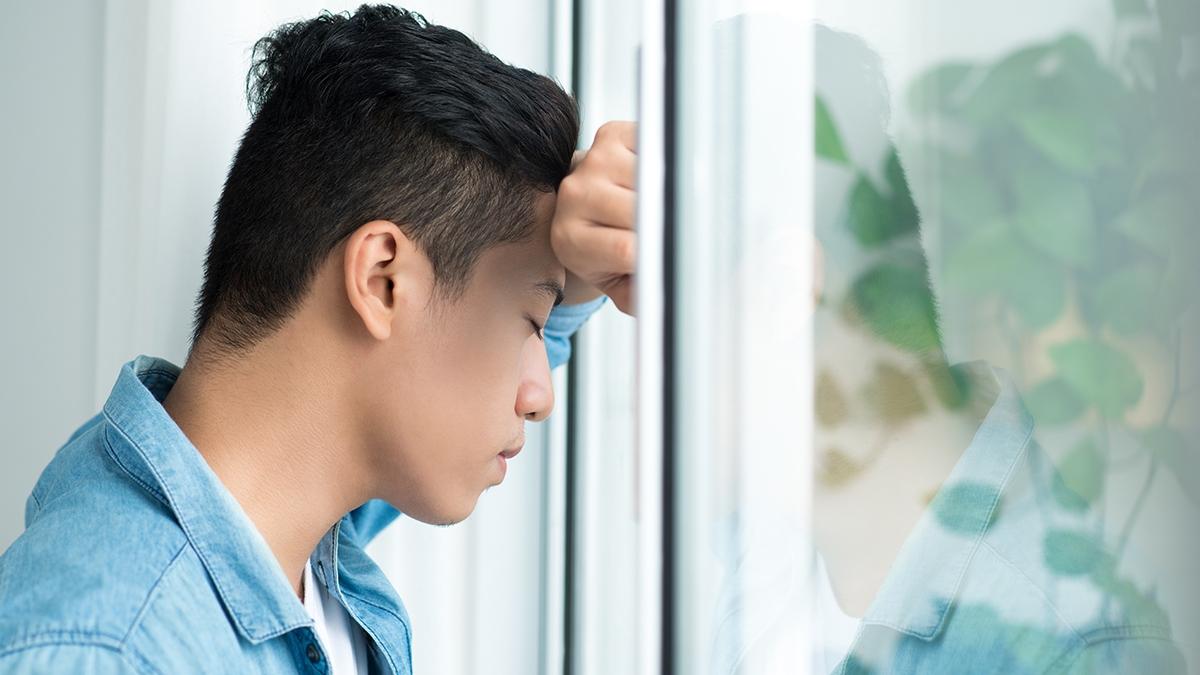 Article Cards Featured Image Casual businessman leaning on window looking worried in the office