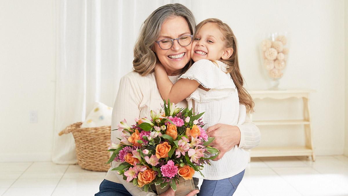 Article Cards Featured Image grandparents day grandmother hugging granddaughter with flowers