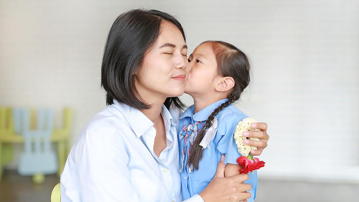 Article Cards Featured Image Portrait Asian little girl kissing her mom and hugging on Mother