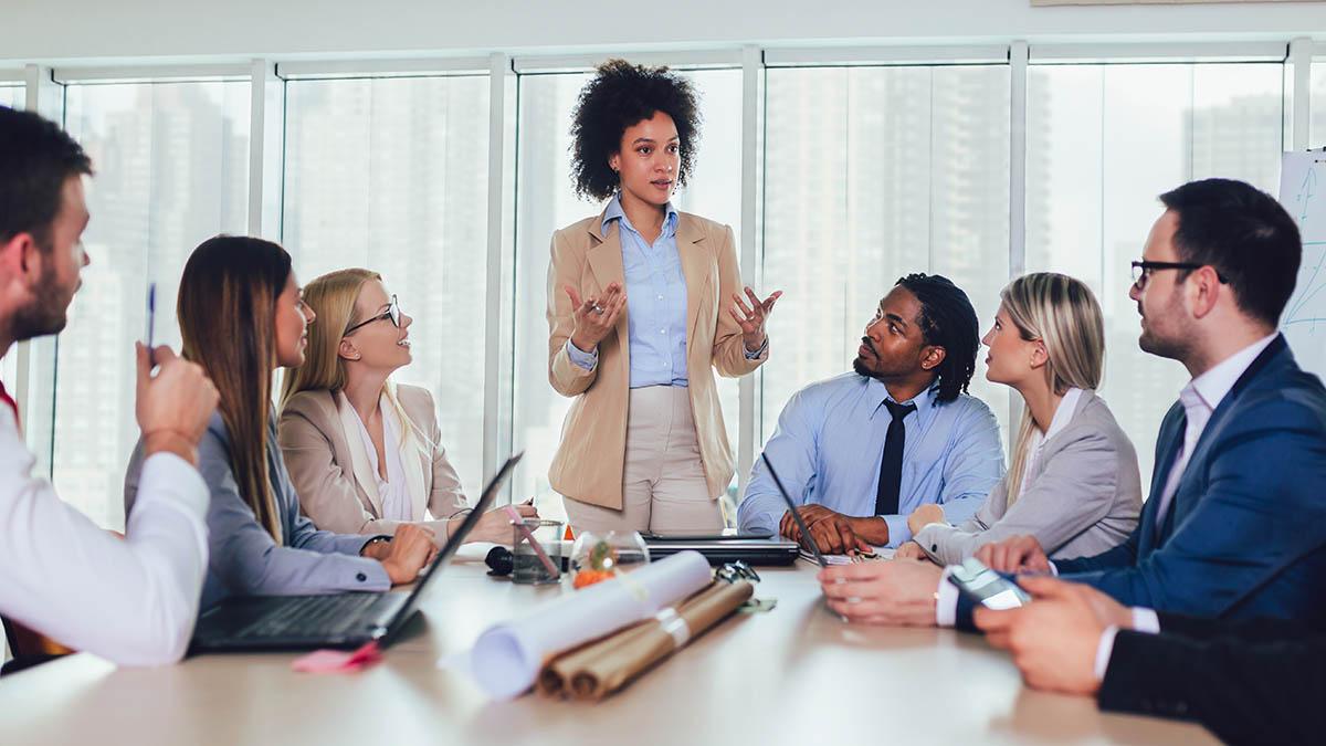 Article Cards Featured Image Photo of a meeting at a diverse workplace, illustrating the importance of workplace diversity.