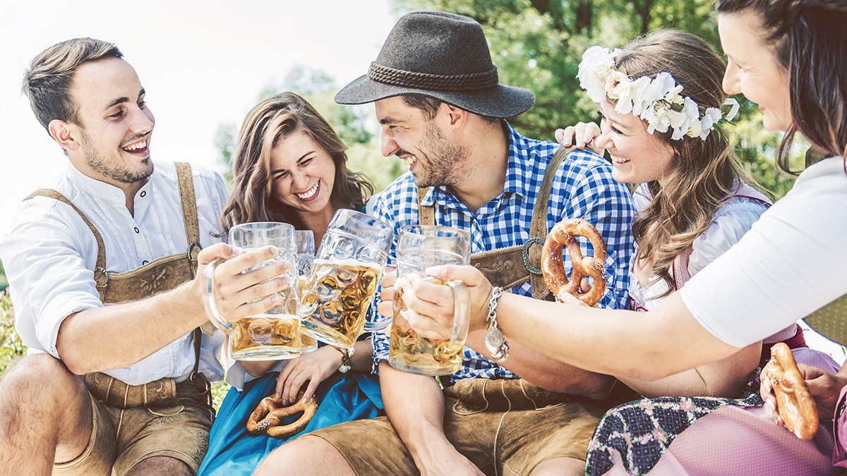 Freunde in trachtenmode entschpannen an der Isar