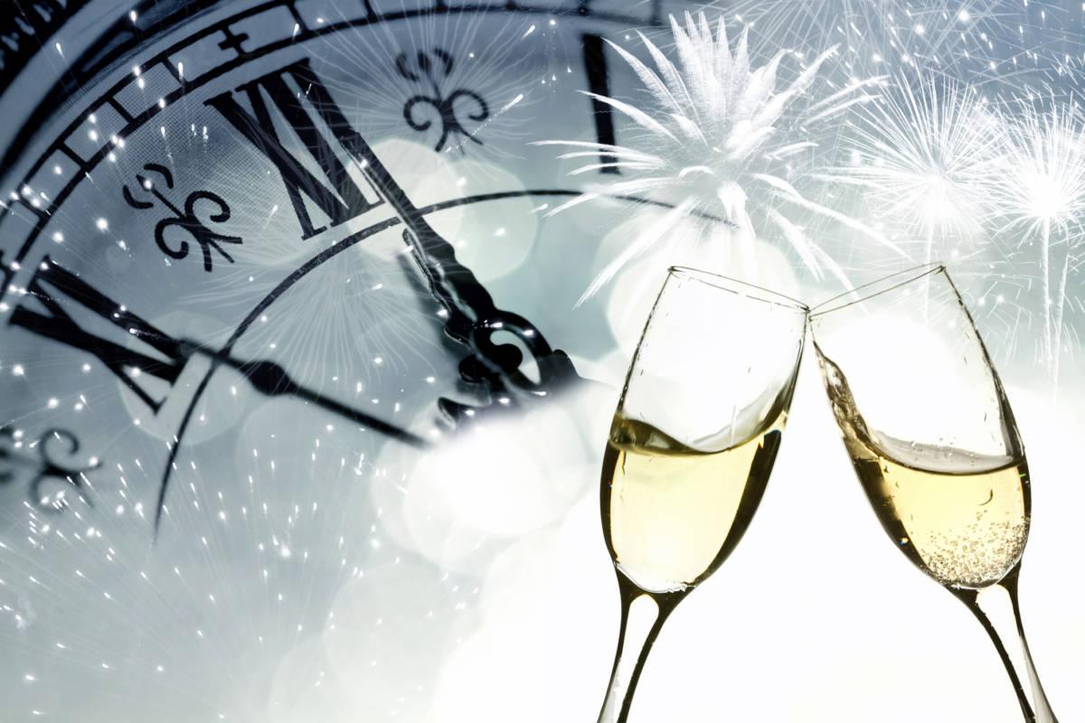 Article Cards Featured Image Glasses with champagne against fireworks and clock