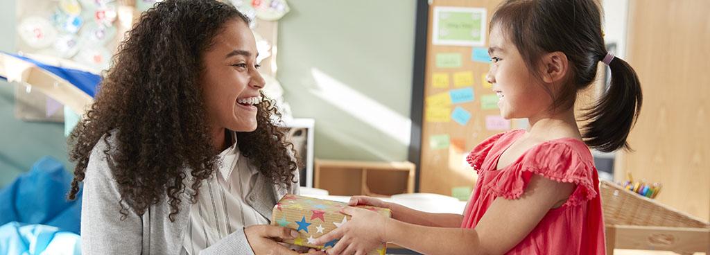 back to school celebration with girl giving teacher gift