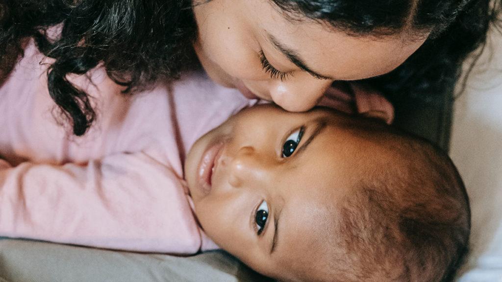 A mother kissing her baby, another effect of mommy brain. A way nature alters mothers’ brains is by essentially making babies addictive.