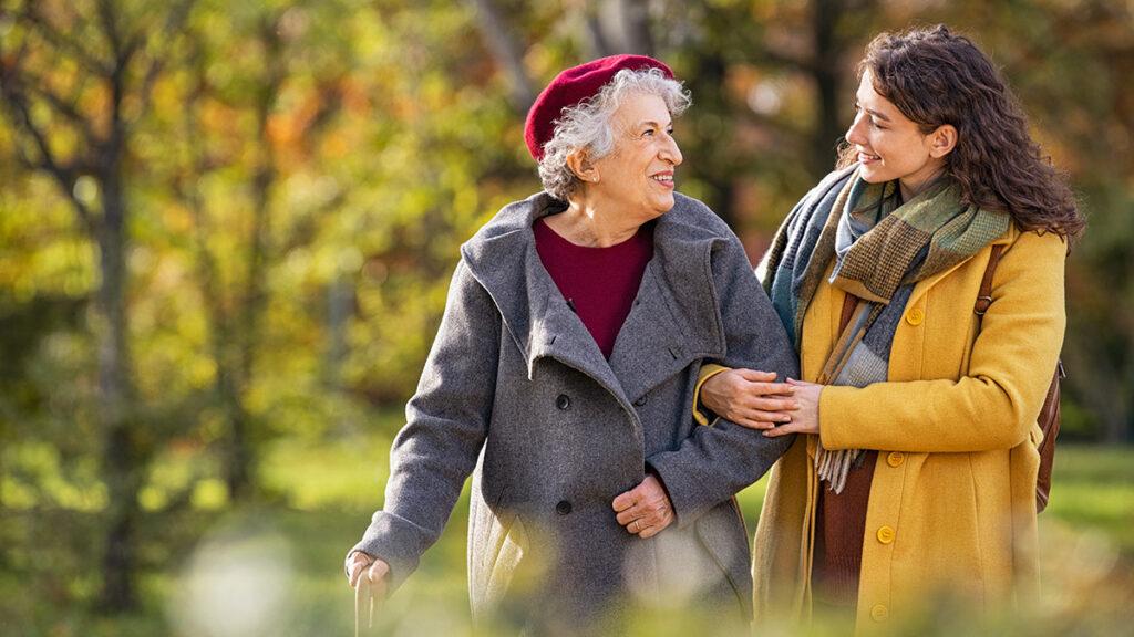 caregivers with young woman taking walking with older woman